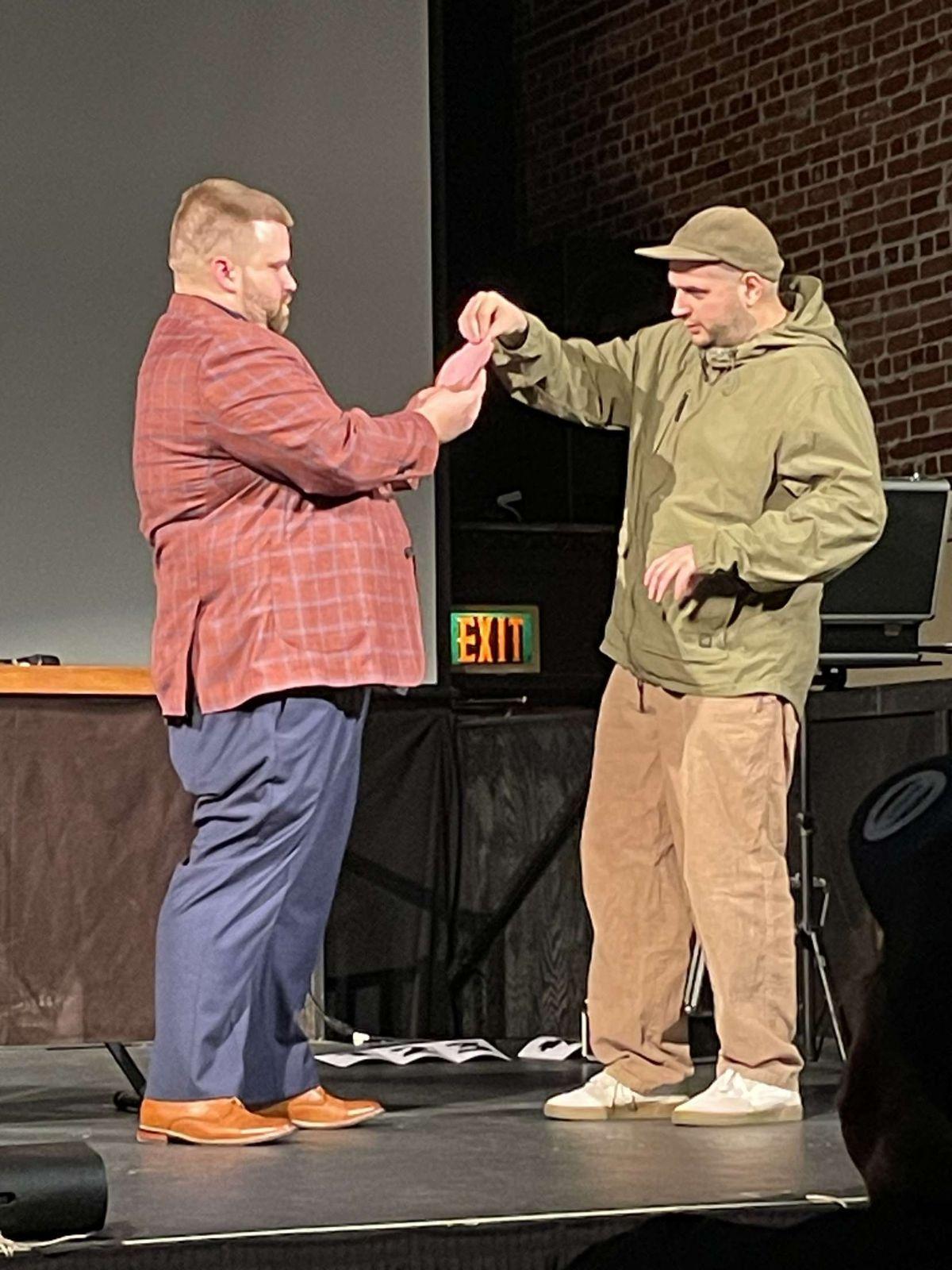 Nate Heater performing a stage magic routine with a volunteer